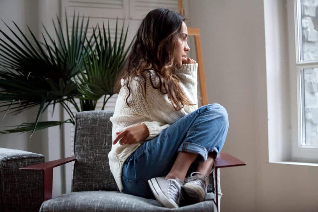 Sad thoughtful girl sitting on chair